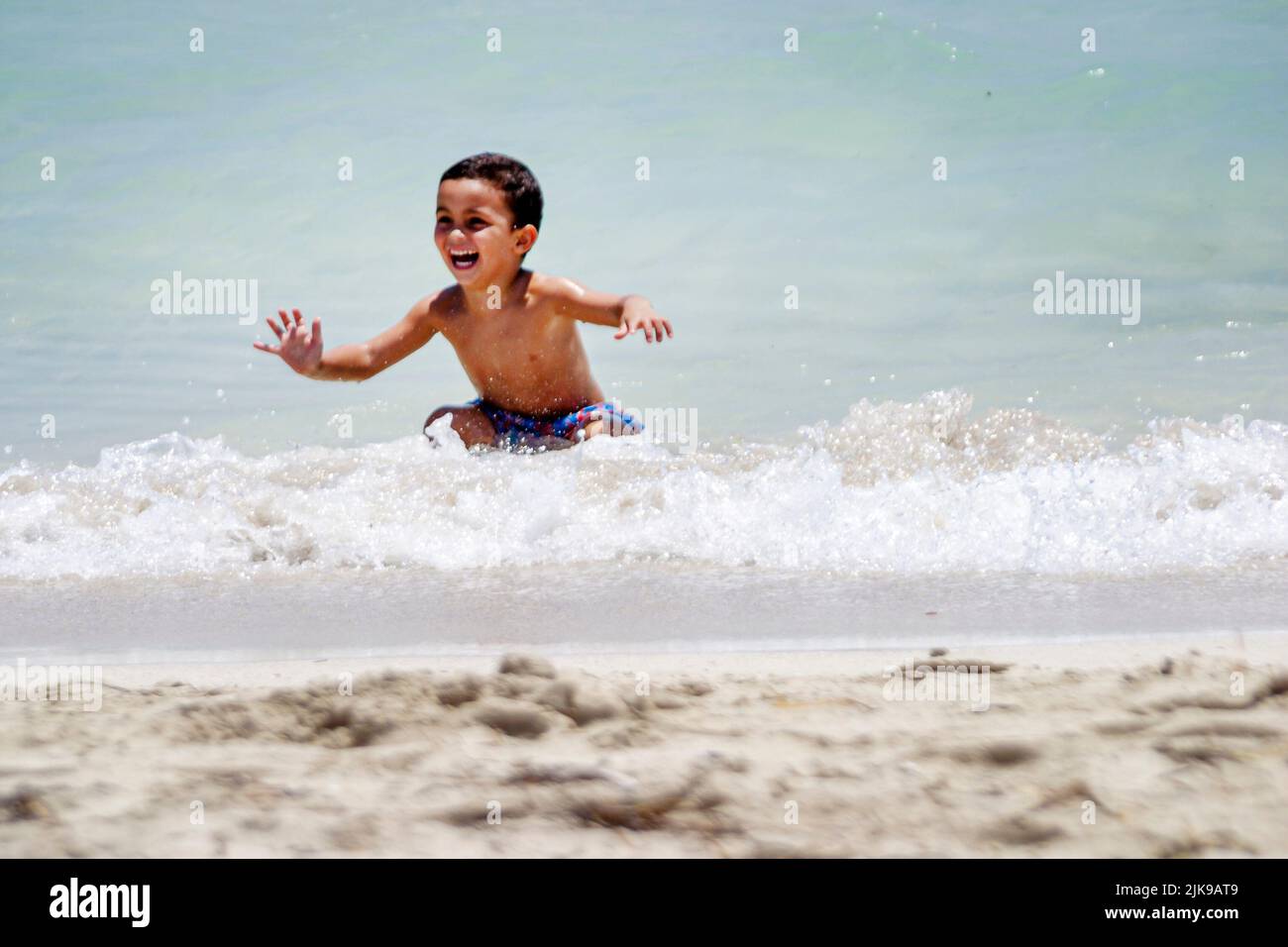 Miami Beach Florida,Atlantic Ocean public Shore,seashore,Hispanic male,boy boys,kid child youngster youngsters youth youths playing having fun in surf Stock Photo