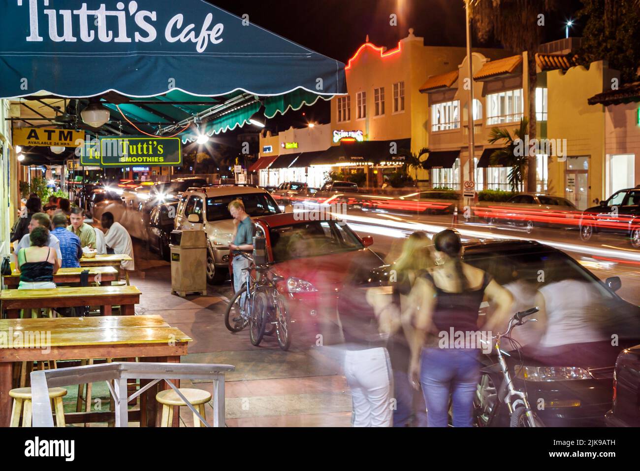 Miami Beach Florida,Collins Avenue,night nightlife evening after dark,al fresco dining Tutti's Cafe restaurant visitors group people person tables Stock Photo