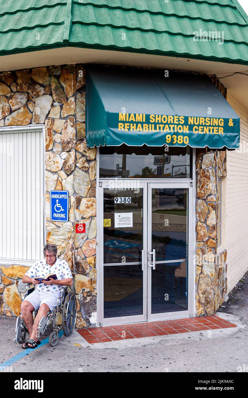 Hialeah Florida,Miami Shores Nursing & Rehabilitation Center,centre,adult,adults,man men male,sitting in wheelchair by entrance reading,people person Stock Photo