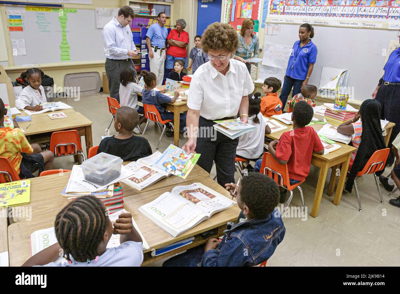 Miami Florida,Frederick Douglass Elementary School low income Hispanic students boys,Black girls class classroom visitors from law firm donating books Stock Photo