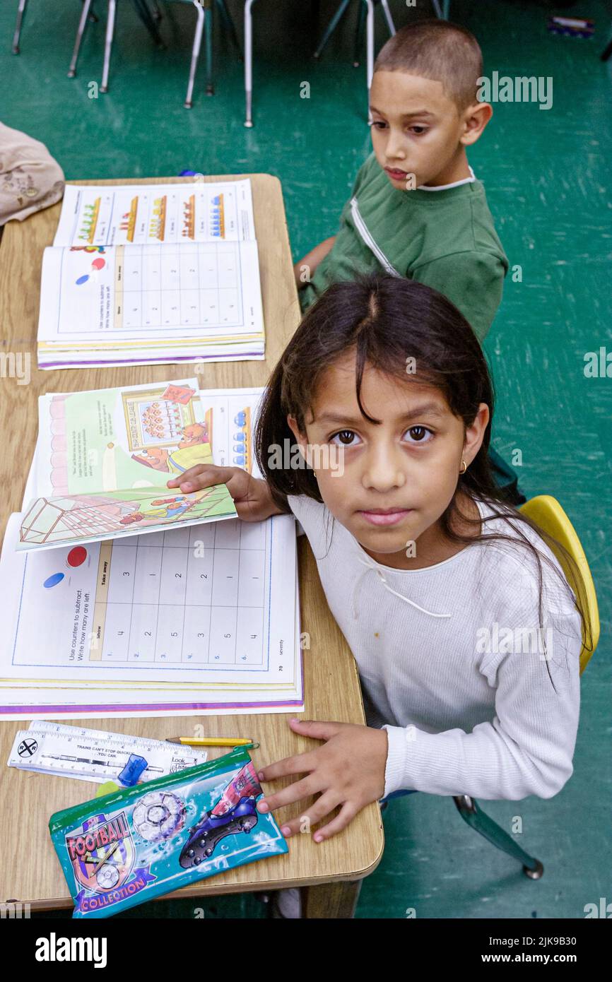 Miami Florida,Frederick Douglass Elementary School,low income neighborhood community,Hispanic students girl boy children classroom desk workbook book Stock Photo