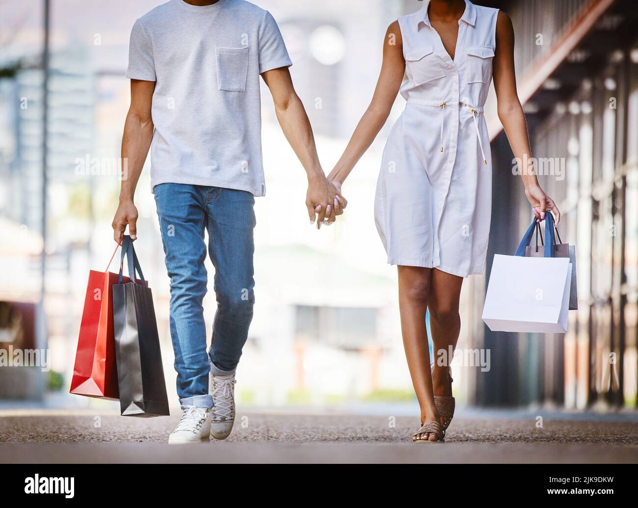 If shes having a bad day, take her shopping. a young couple walking hand in  hand while holding shopping bags Stock Photo - Alamy