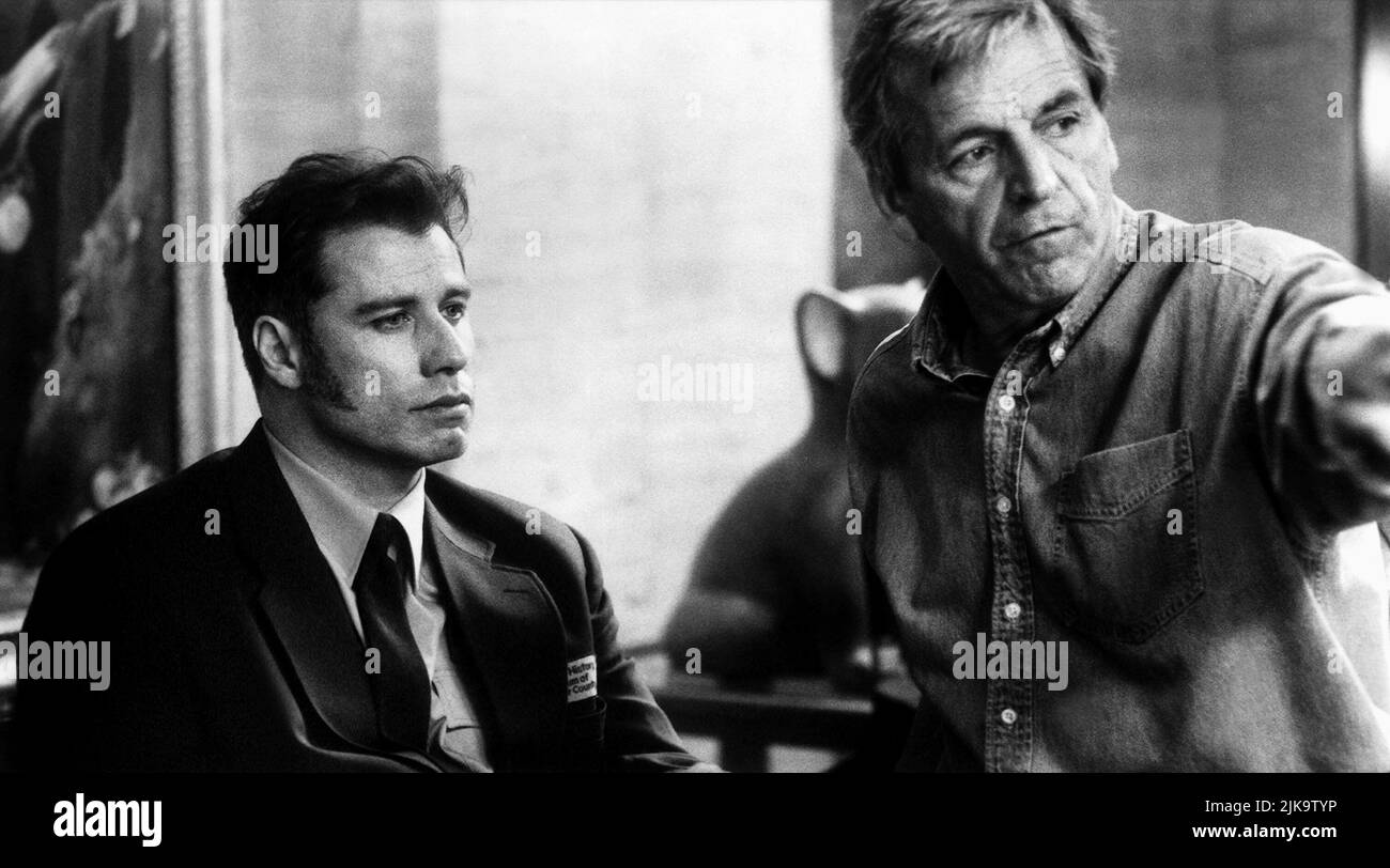 John Travolta,Constantin Costa-Gavras Film: Mad City (1997) Characters: Sam Baily,  Director: Costa-Gavras 10 October 1997   **WARNING** This Photograph is for editorial use only and is the copyright of WARNER BROS and/or the Photographer assigned by the Film or Production Company and can only be reproduced by publications in conjunction with the promotion of the above Film. A Mandatory Credit To WARNER BROS is required. The Photographer should also be credited when known. No commercial use can be granted without written authority from the Film Company. Stock Photo