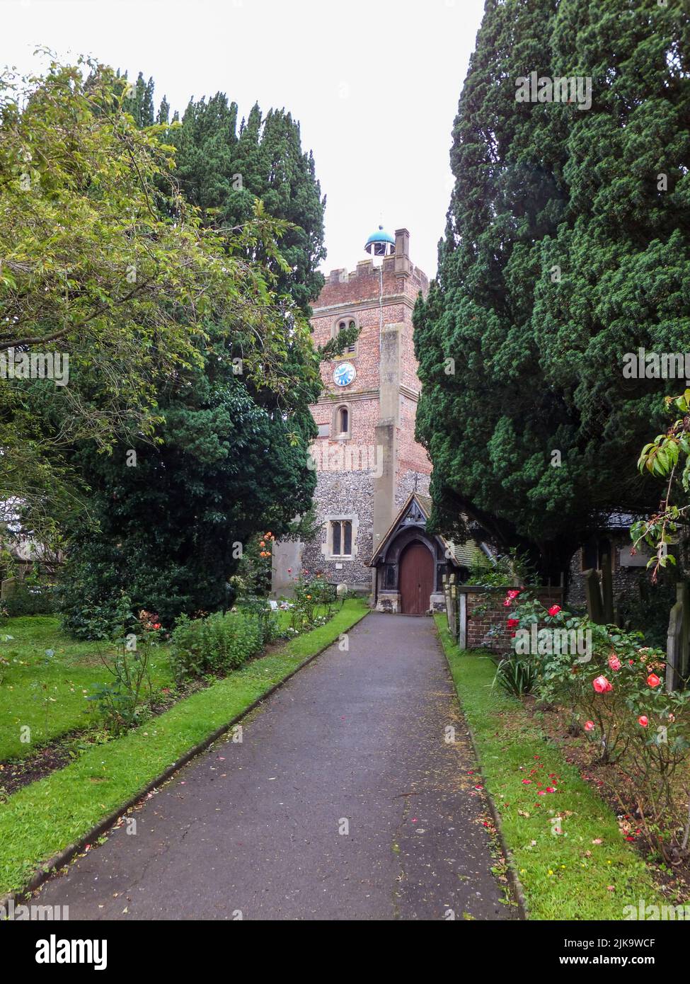 A sidewalk leads to historic St. Mary the Virgin Church in Harmondsworth, Hillingdon, Middlesex, London, England, UK. Stock Photo
