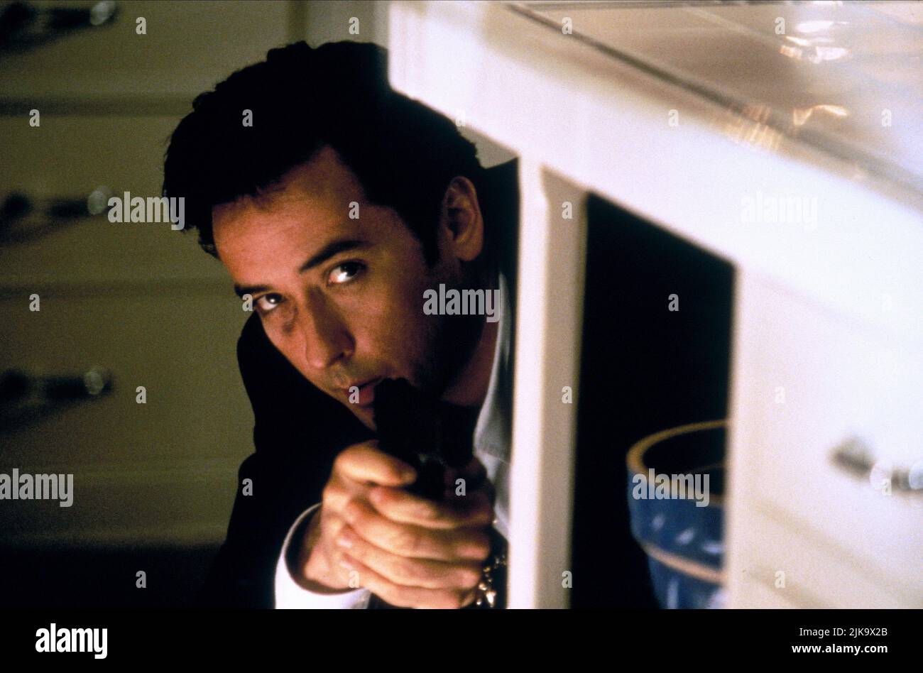 John Cusack Film: Grosse Pointe Blank (1998) Characters: Martin Q. Blank  Director: George Armitage 11 April 1997   **WARNING** This Photograph is for editorial use only and is the copyright of BUENA VISTA and/or the Photographer assigned by the Film or Production Company and can only be reproduced by publications in conjunction with the promotion of the above Film. A Mandatory Credit To BUENA VISTA is required. The Photographer should also be credited when known. No commercial use can be granted without written authority from the Film Company. Stock Photo