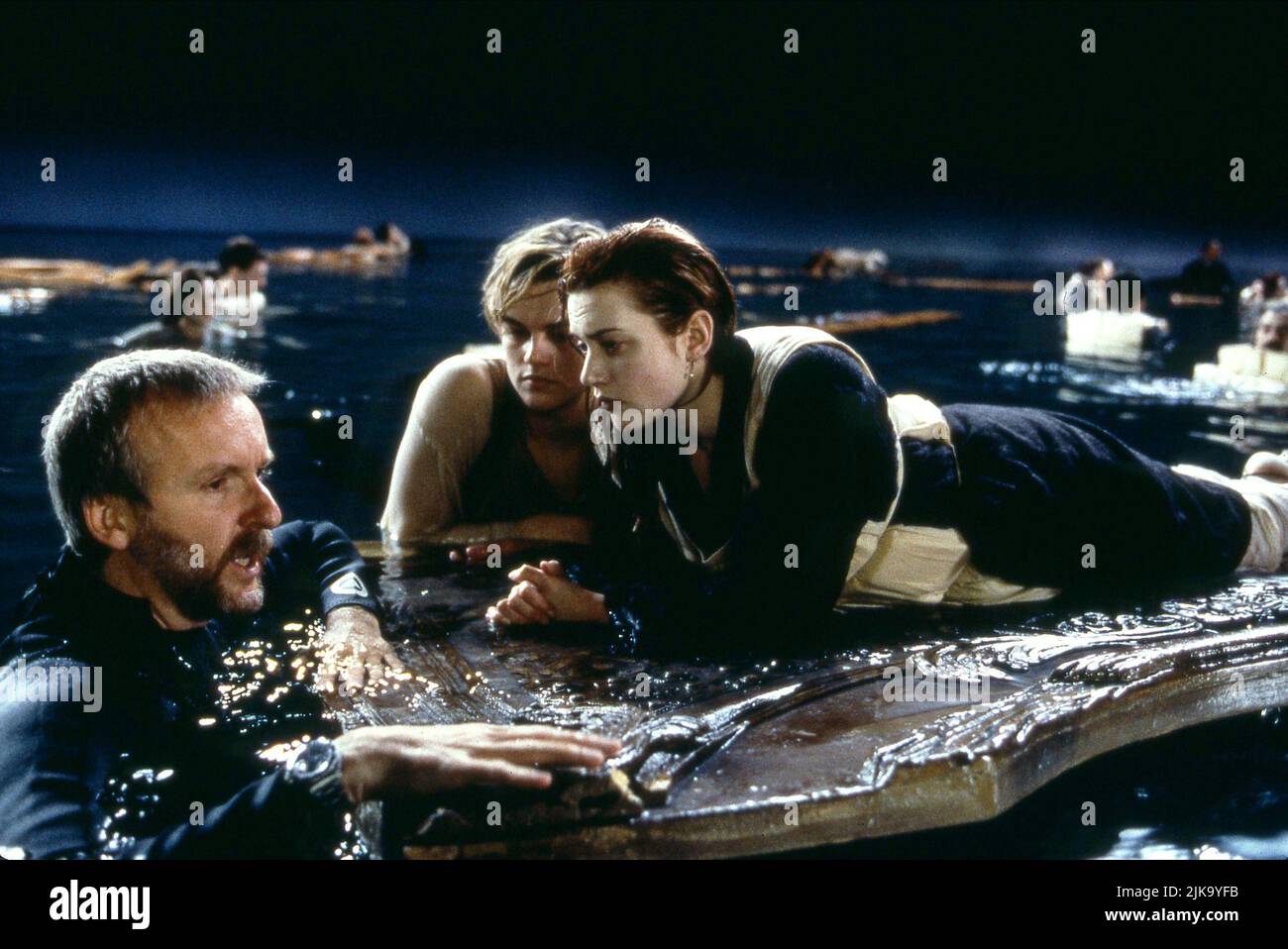 James Cameron, Leonardo Dicaprio & Kate Winslet Film: Titanic (USA 1997) Characters: DIRECTOR, Jack Dawson, Rose DeWitt Bukater  Director: James Cameron 01 November 1997   **WARNING** This Photograph is for editorial use only and is the copyright of 20TH CENTURY FOX and/or the Photographer assigned by the Film or Production Company and can only be reproduced by publications in conjunction with the promotion of the above Film. A Mandatory Credit To 20TH CENTURY FOX is required. The Photographer should also be credited when known. No commercial use can be granted without written authority from t Stock Photo