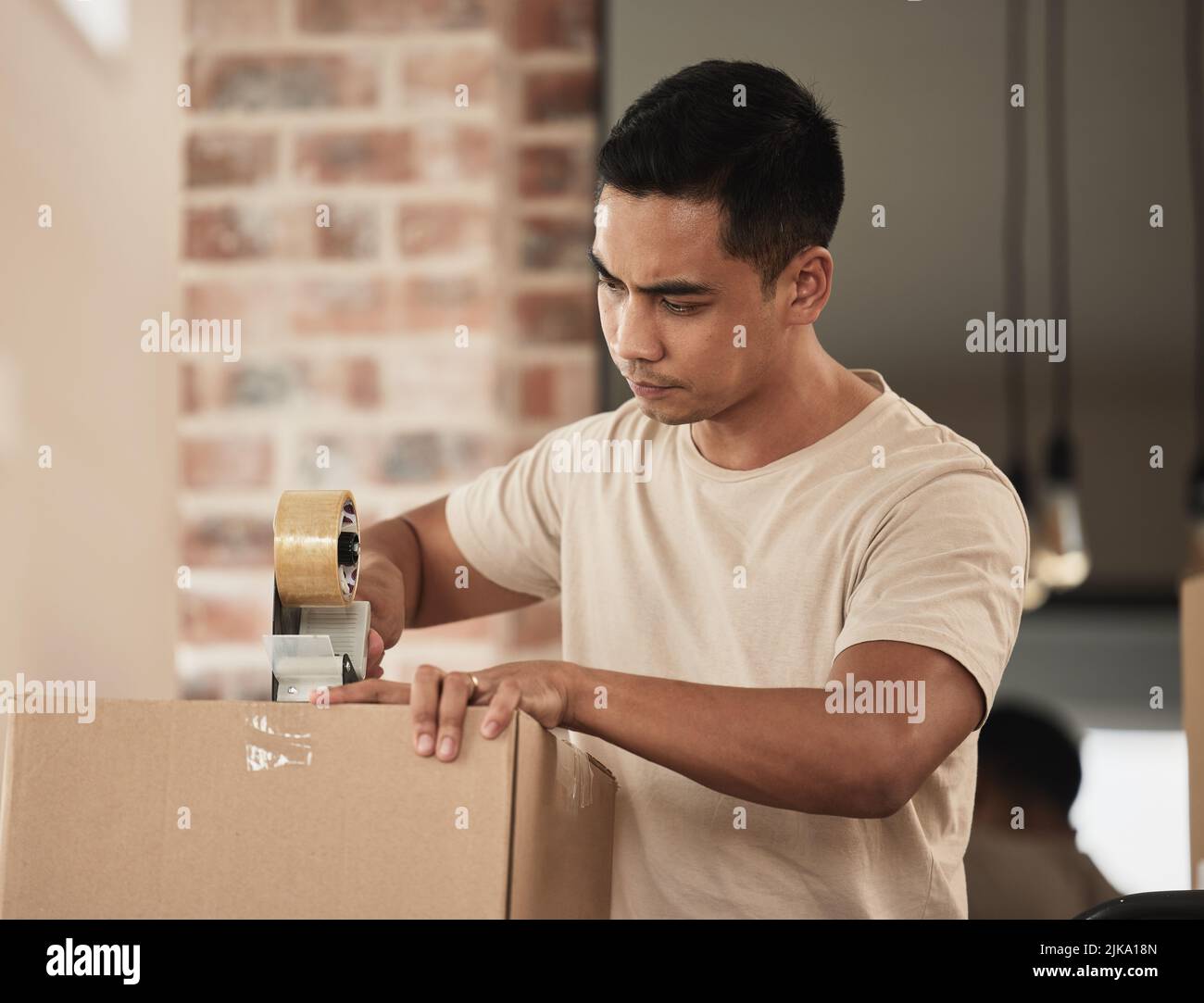Sometimes its necessary to move house. a young man packing up to move in a room at home. Stock Photo