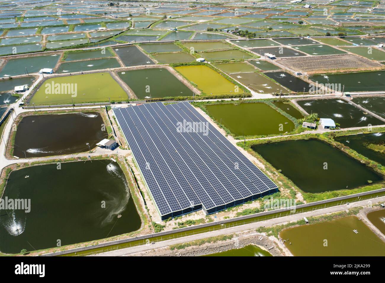 Aerial view of Solar panel farm on  fish pond for electricity generation Stock Photo