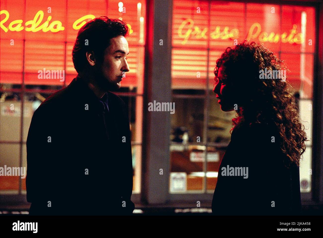 John Cusack & Minnie Driver Film: Grosse Pointe Blank (1997) Characters: Martin Q. Blank & Debi Newberry  Director: George Armitage 11 April 1997   **WARNING** This Photograph is for editorial use only and is the copyright of BUENA VISTA and/or the Photographer assigned by the Film or Production Company and can only be reproduced by publications in conjunction with the promotion of the above Film. A Mandatory Credit To BUENA VISTA is required. The Photographer should also be credited when known. No commercial use can be granted without written authority from the Film Company. Stock Photo
