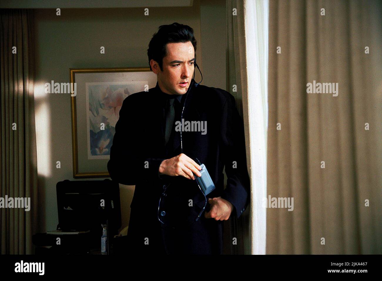 John Cusack Film: Grosse Pointe Blank (1997) Characters: Martin Q. Blank  Director: George Armitage 11 April 1997   **WARNING** This Photograph is for editorial use only and is the copyright of BUENA VISTA and/or the Photographer assigned by the Film or Production Company and can only be reproduced by publications in conjunction with the promotion of the above Film. A Mandatory Credit To BUENA VISTA is required. The Photographer should also be credited when known. No commercial use can be granted without written authority from the Film Company. Stock Photo