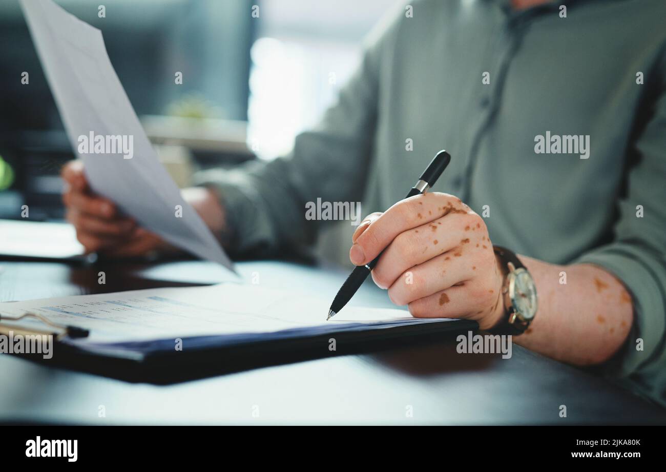 I just need to sign this form. an unrecognizable businessman doing ...