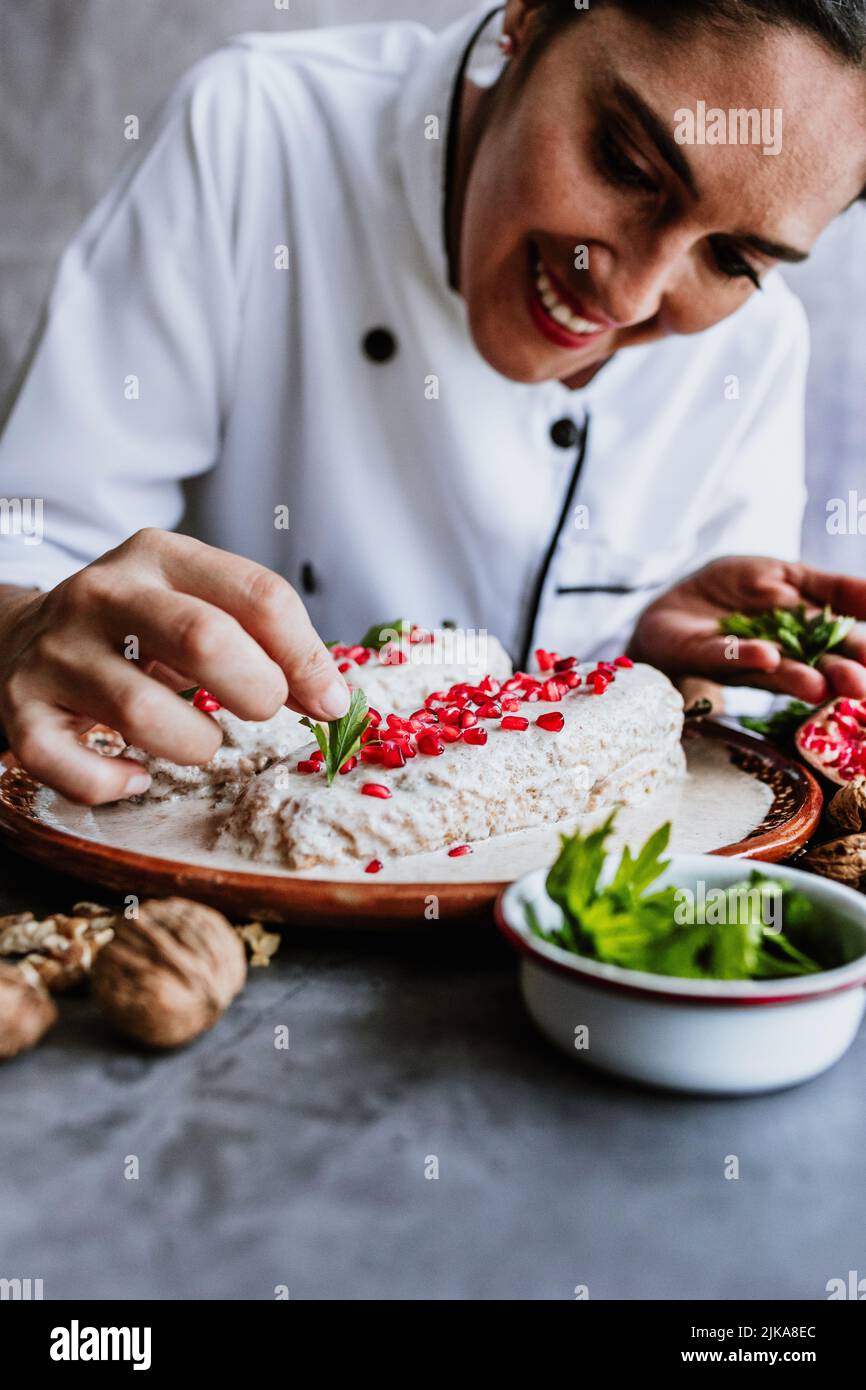 cooking mexican chiles en nogada recipe by woman chef hands with