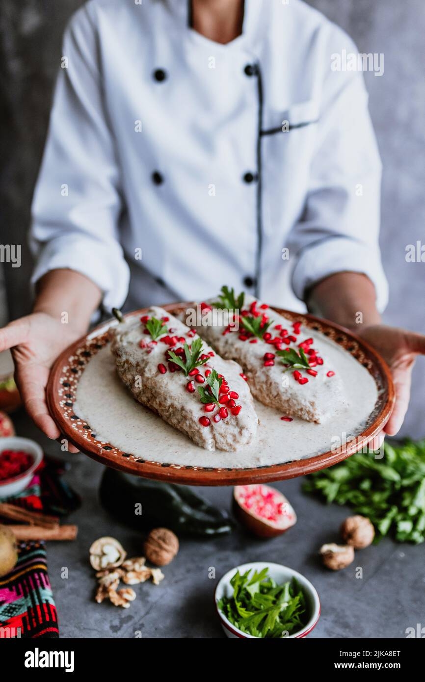 cooking mexican chiles en nogada recipe by woman chef hands with