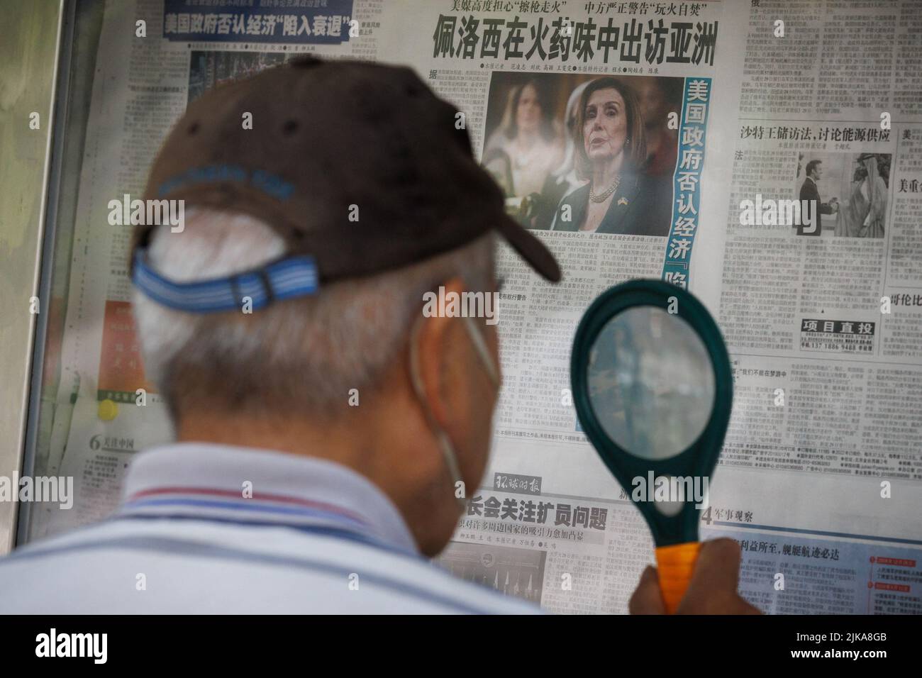 A man reads the Global Times newspaper that features a front page article about U.S. House of Representatives Speaker Nancy Pelosi's Asia tour at a street display wall in Beijing, China, August 1, 2022. The front page headline reads: 'Pelosi visits Asia in the smell of gunpowder.'  REUTERS/Thomas Peter Stock Photo