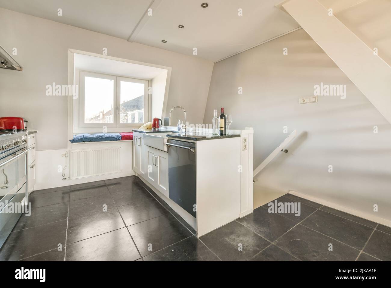 Contemporary cupboards with appliances and tables with kitchenware