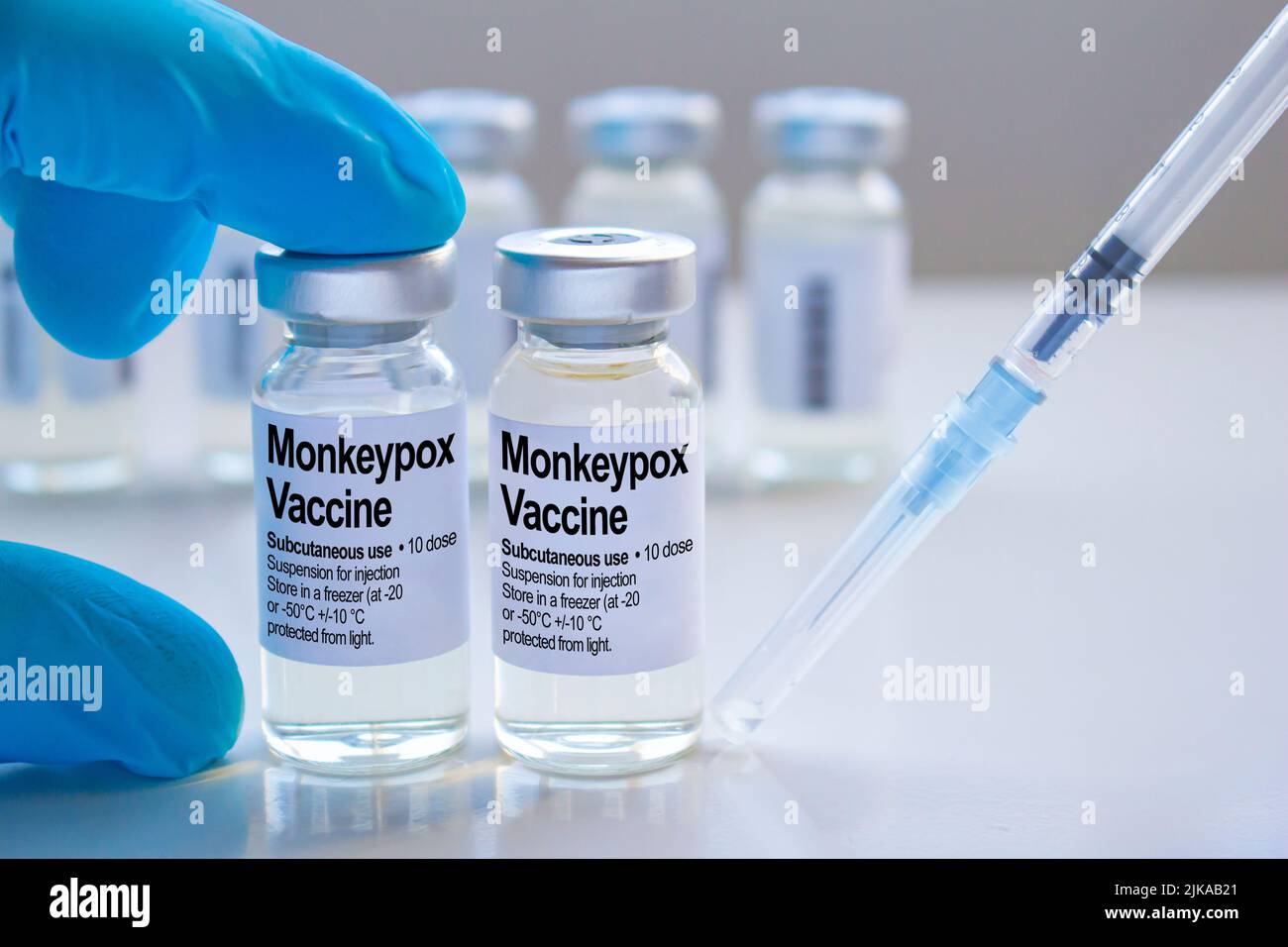 A healthcare worker holding a Monkeypox vaccine vial next to a syringe ...