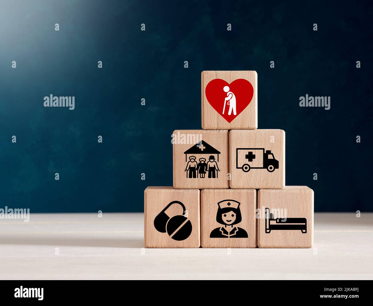Elderly care concept. Wooden cubes with elderly care icons of medical and nursing care, rehabilitation service for enhancing quality of life in elder Stock Photo