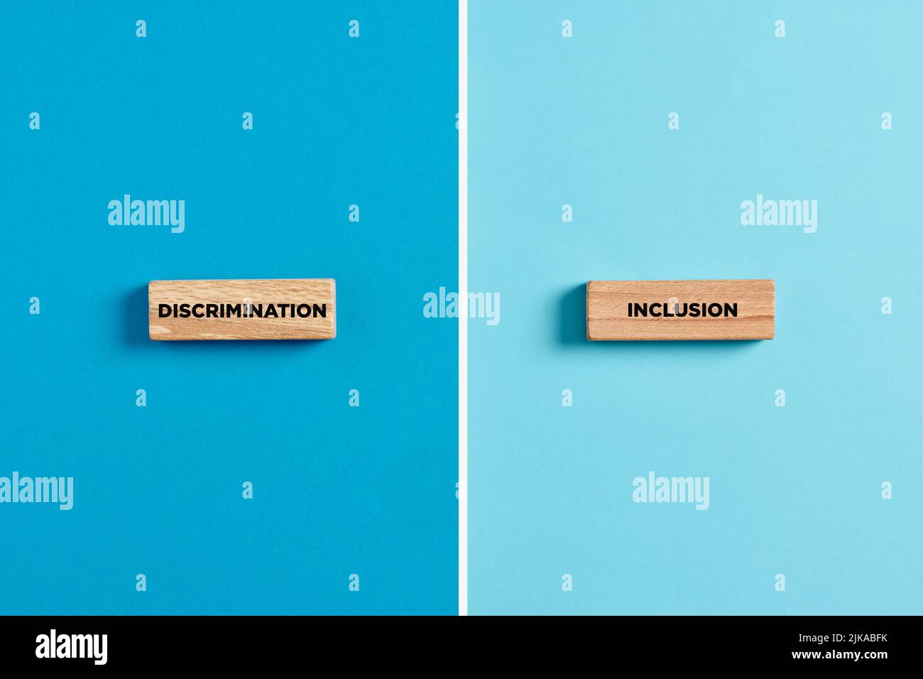 The words discrimination and inclusion on wooden blocks. Dilemma or choice between discrimination or inclusion concept. Stock Photo
