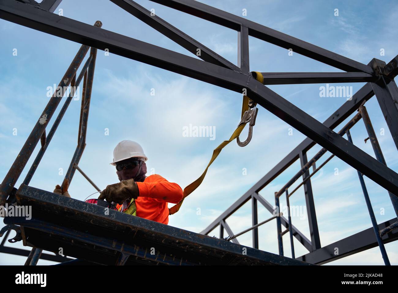 A Worker are working on the structure of the building with Fall arrestor device for worker with hooks for safety body harness at construction site. Stock Photo