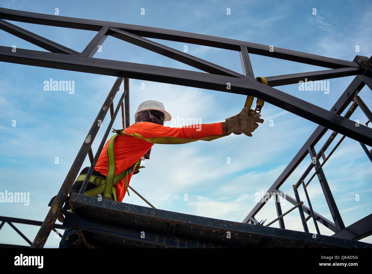 A worker are using Fall arrestor device for worker with hooks for safety body harness on onstruction site. Stock Photo