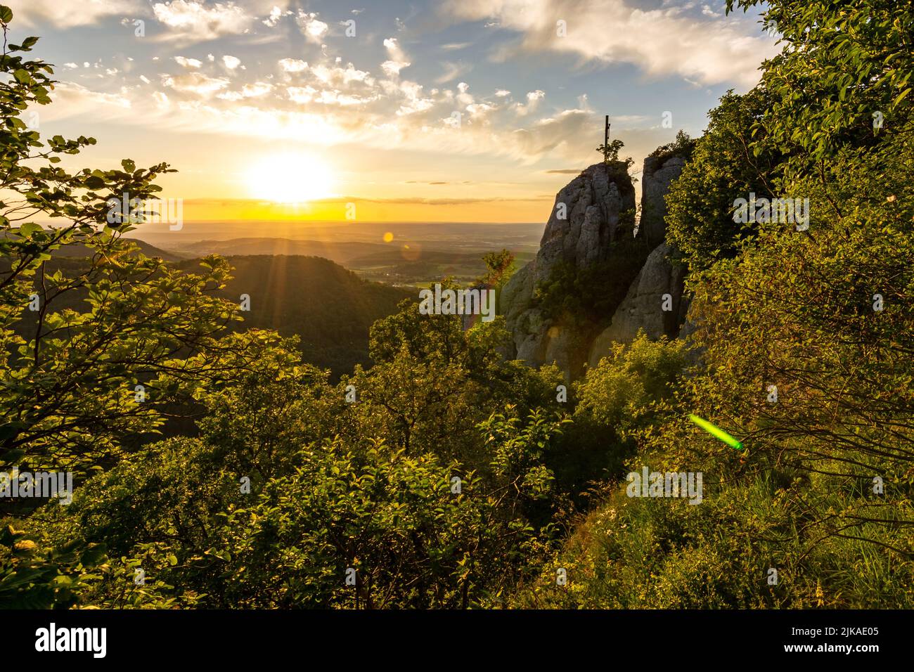 Dramatic sunset over scenic rock ledge and trees in the Swabian Jura in Southern Germany Stock Photo