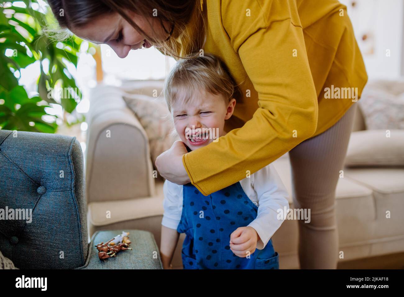 Mother consoling her little crying daughter at home. Stock Photo