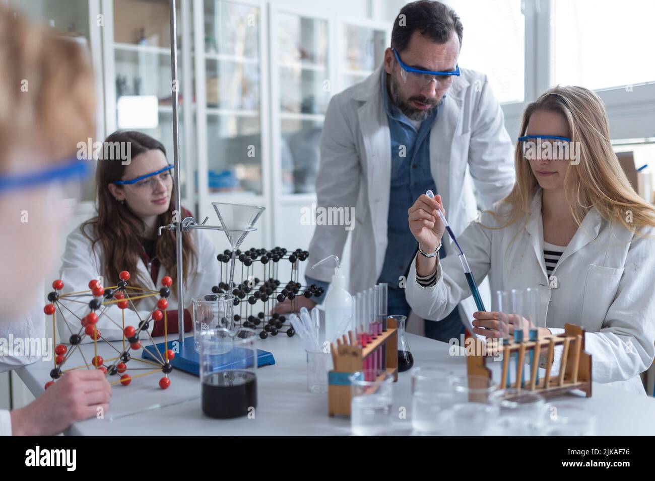Science students with teacher doing chemical reaction experiment in the laboratory at university. Stock Photo