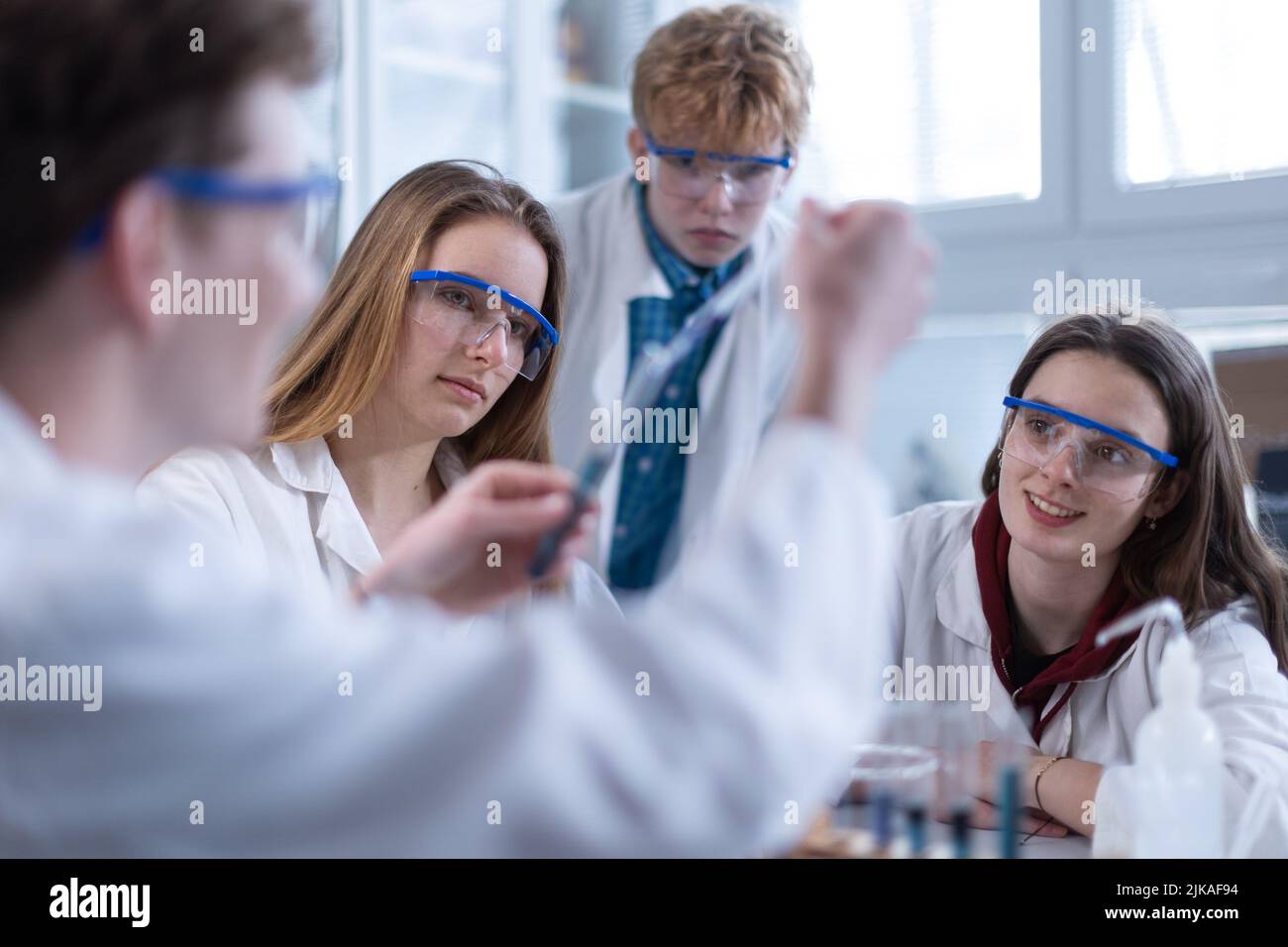 Science students with teacher doing chemical experiment in the laboratory at university. Stock Photo
