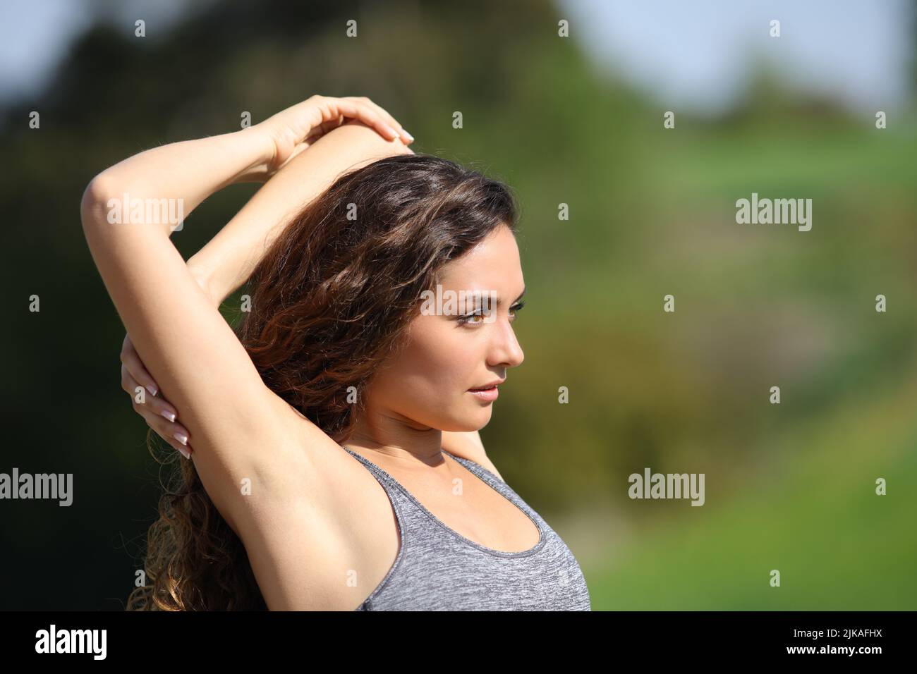 Sportswoman stretching arms looking away in the mountain after sport Stock Photo