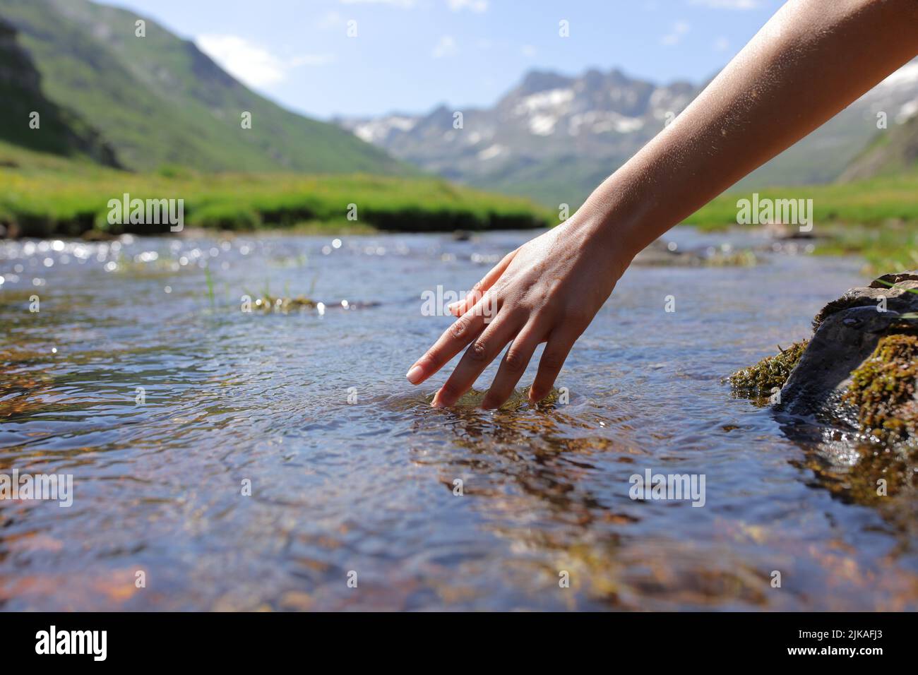 Clos eup of a woman wand touching river water in the mountain Stock Photo