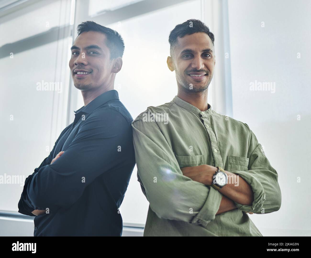 Hes got my back, and Ive got his. Cropped portrait of two handsome young businessmen standing back to back with their arms folded in their office. Stock Photo