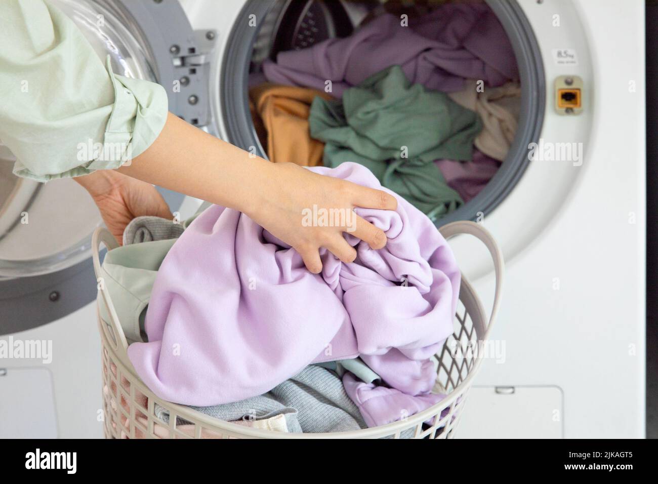 aesthetic laundry concept Putting laundry into the washing machine Stock Photo - Alamy