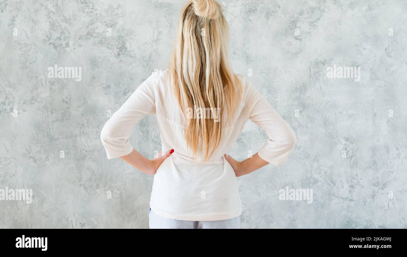taking decision blonde woman hands hips backview Stock Photo