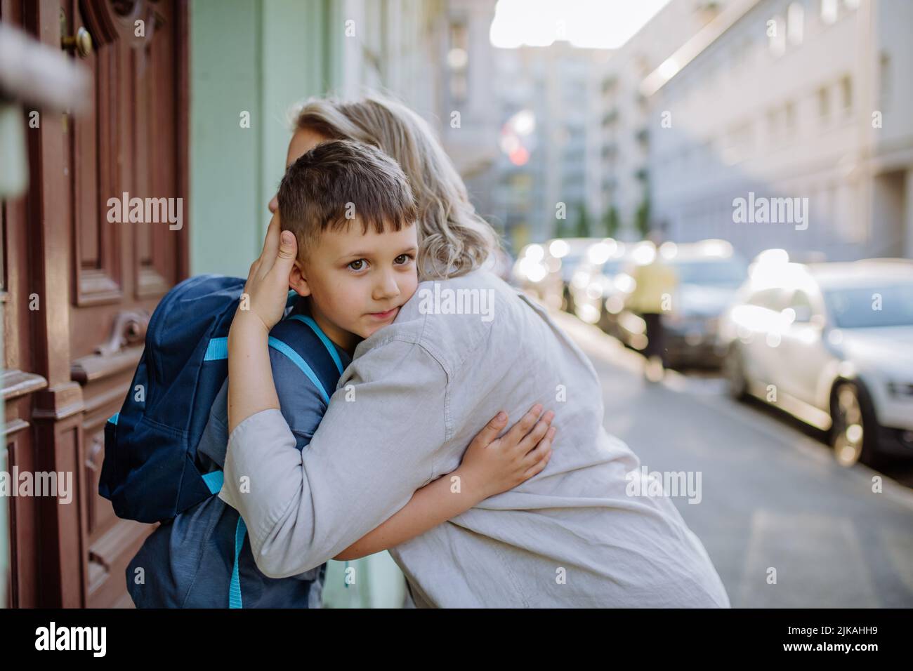 Mother hugs her young son on the way to school, and a mother and boy say goodbye before school. Stock Photo