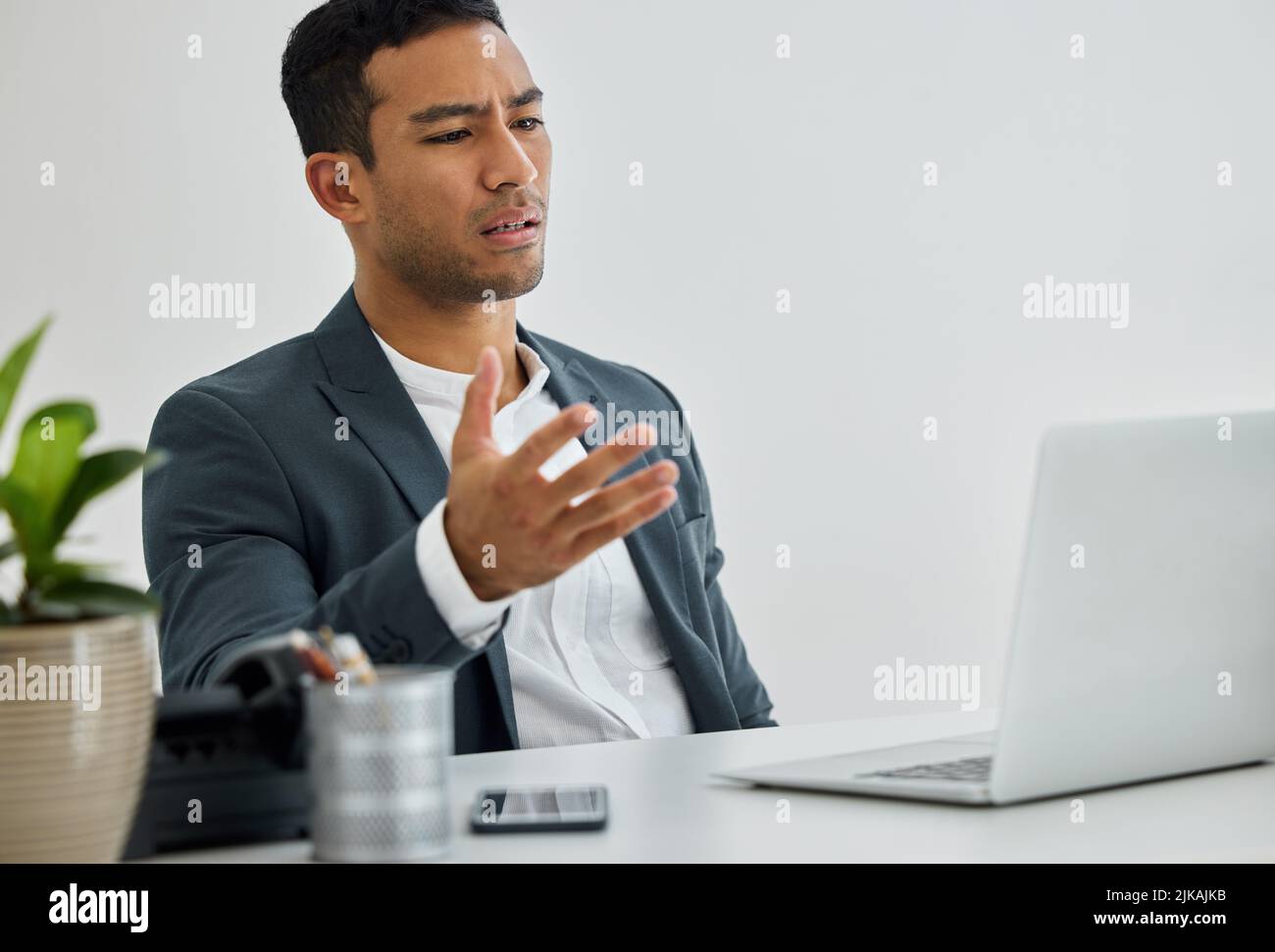 Justice was a promise from the dishonest. a businessman being frustrated while using his laptop at his desk in a modern office. Stock Photo