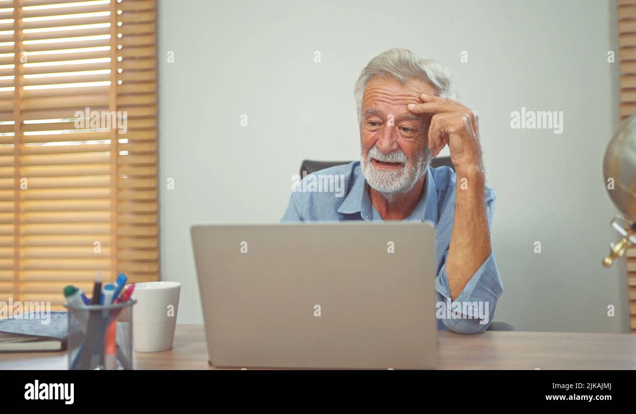 Worried senior man using with laptop computer at home. Stock Photo