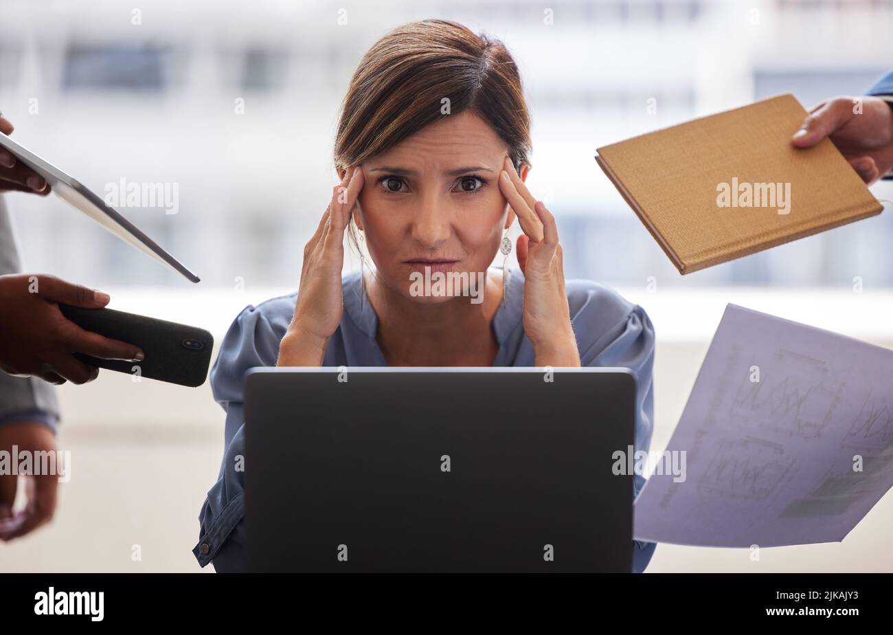 Being in charge isnt always easy. a businesswoman looking overwhelmed in a demanding office environment. Stock Photo