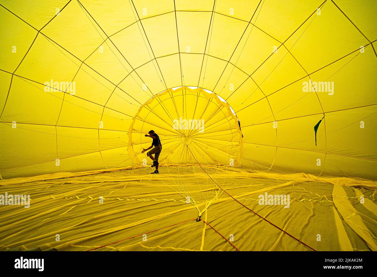 A person checks ropes inside a balloon prior to a flight over Bristol, ahead of the Bristol International Balloon Fiesta 2022. Picture date: Monday August 1, 2022. Stock Photo