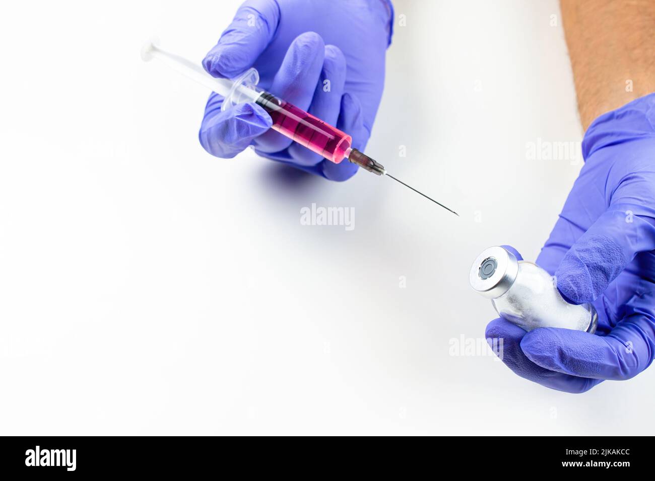 a disposable syringe with a needle and an ampoule with red (vitamin B12