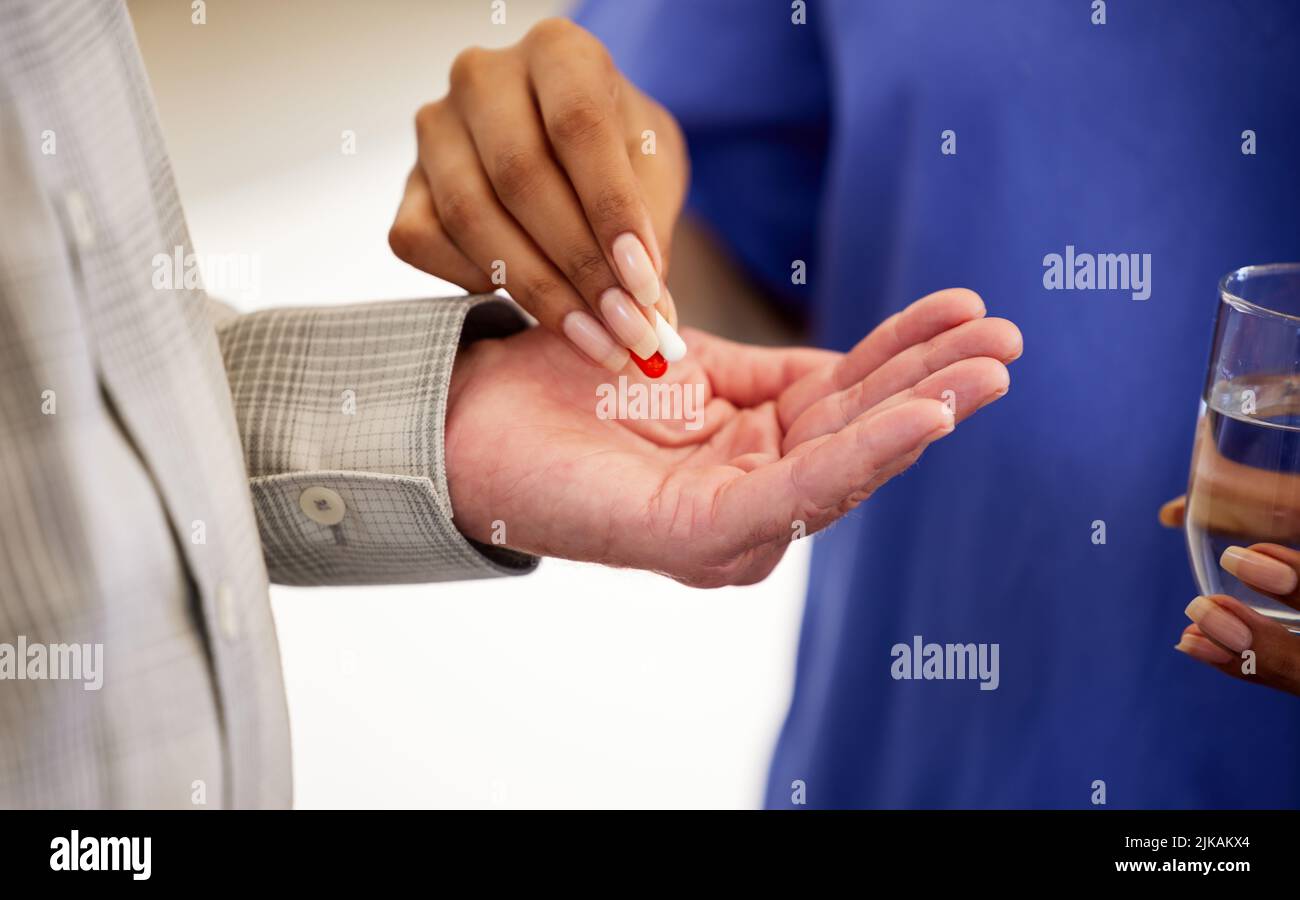 take these every 3 hours. a nurse giving her patient pills. Stock Photo