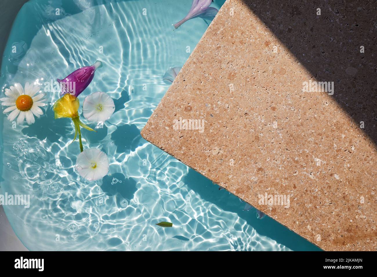 Product promotion Beauty cosmetic showcase. Travertine stone display with flowers in water. Stock Photo