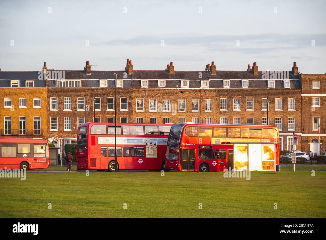 London, UK - November 3, 2018 - Passengers boarding bus around Blackheath with Georgian terraced house in the background Stock Photo