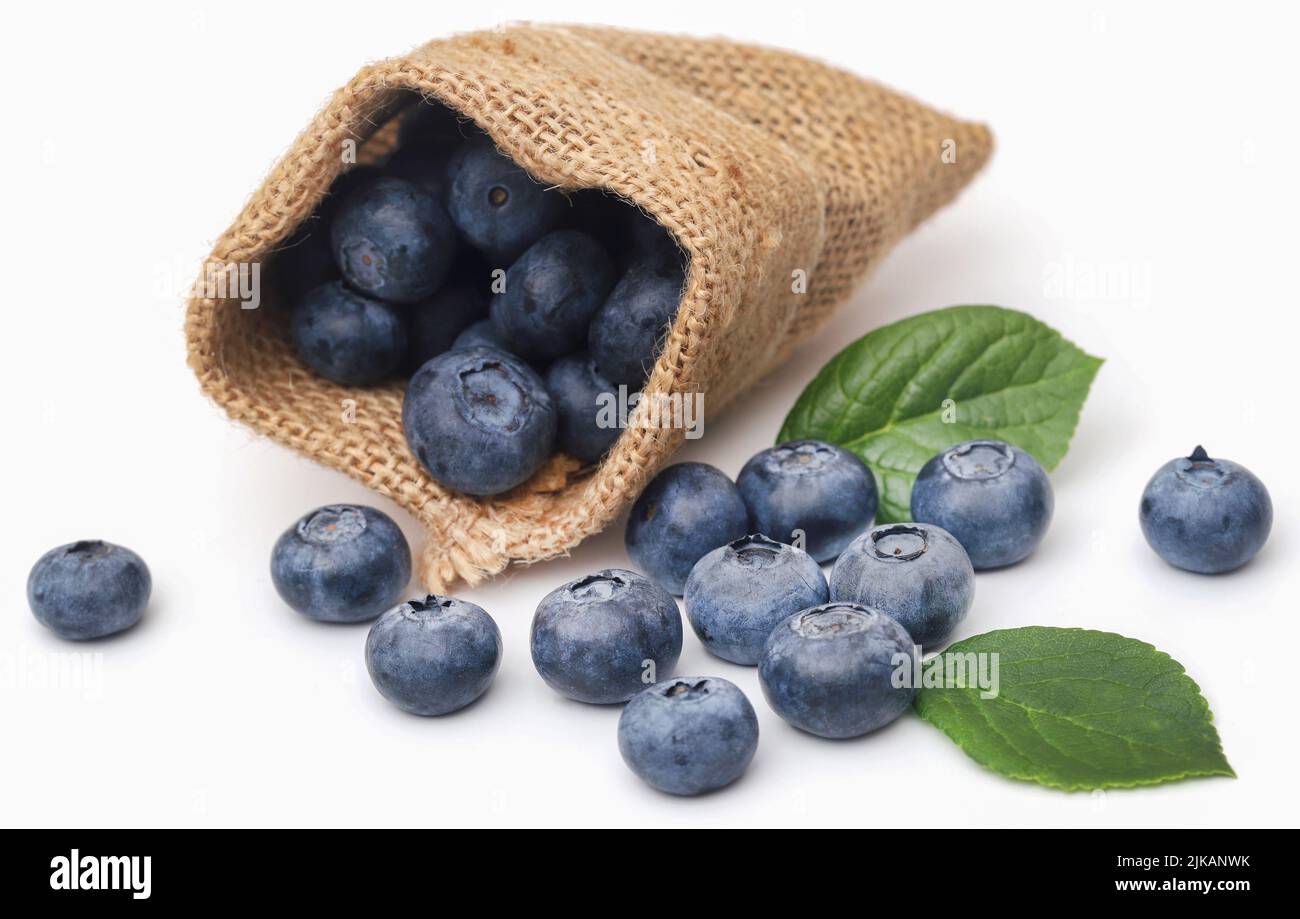 Fresh blueberries with green leaves over white background Stock Photo