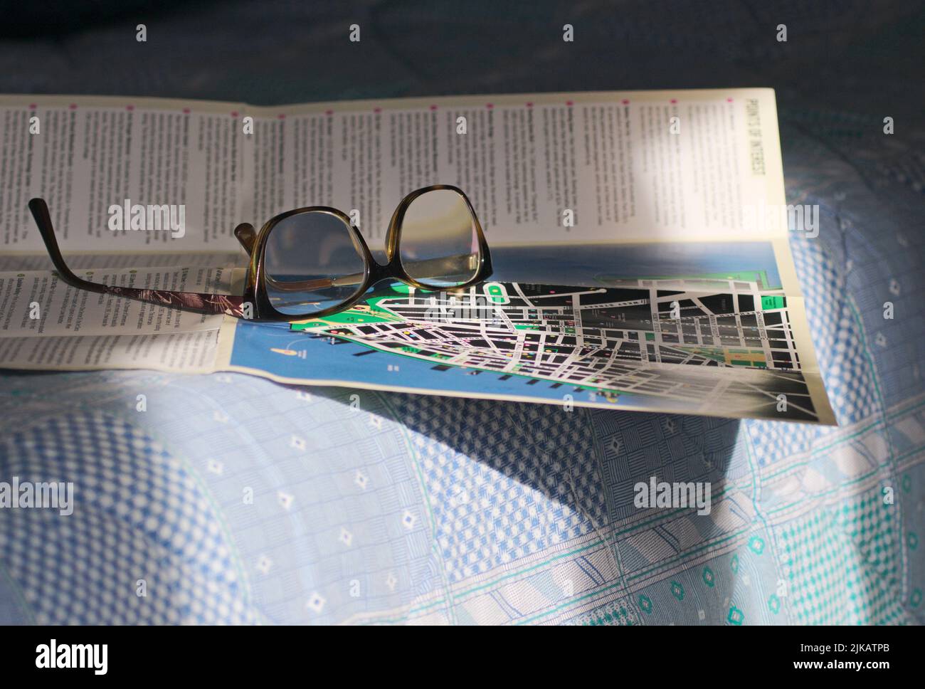 eyeglasses and city map on the bed Stock Photo