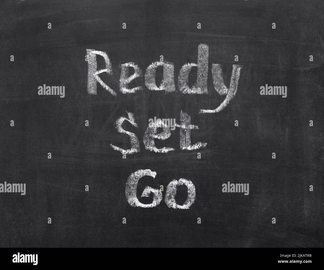 Words Ready, Set, Go written by a chalk on a blackboard Stock Photo