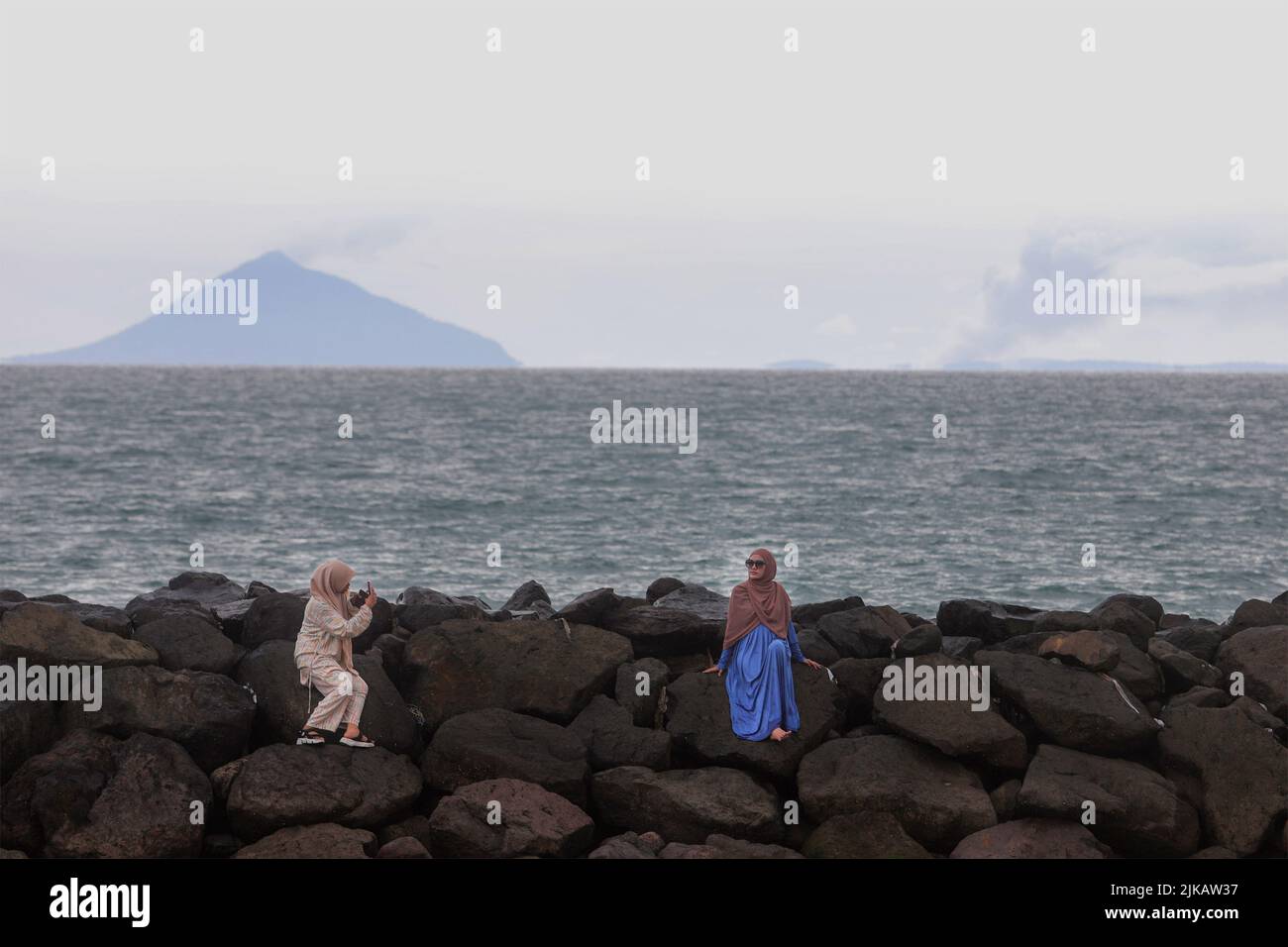 Serang, Indonesia. 01st May, 2022. Women seen taking photos at Cidatu Beach, Carita, Pandeglang, Banten. The status of the Anak Krakatau Volcano (Child of Krakatoa) is at Level III or standby. Fishermen and tourists are prohibited from doing activities within a 5 kilometer radius. Credit: SOPA Images Limited/Alamy Live News Stock Photo