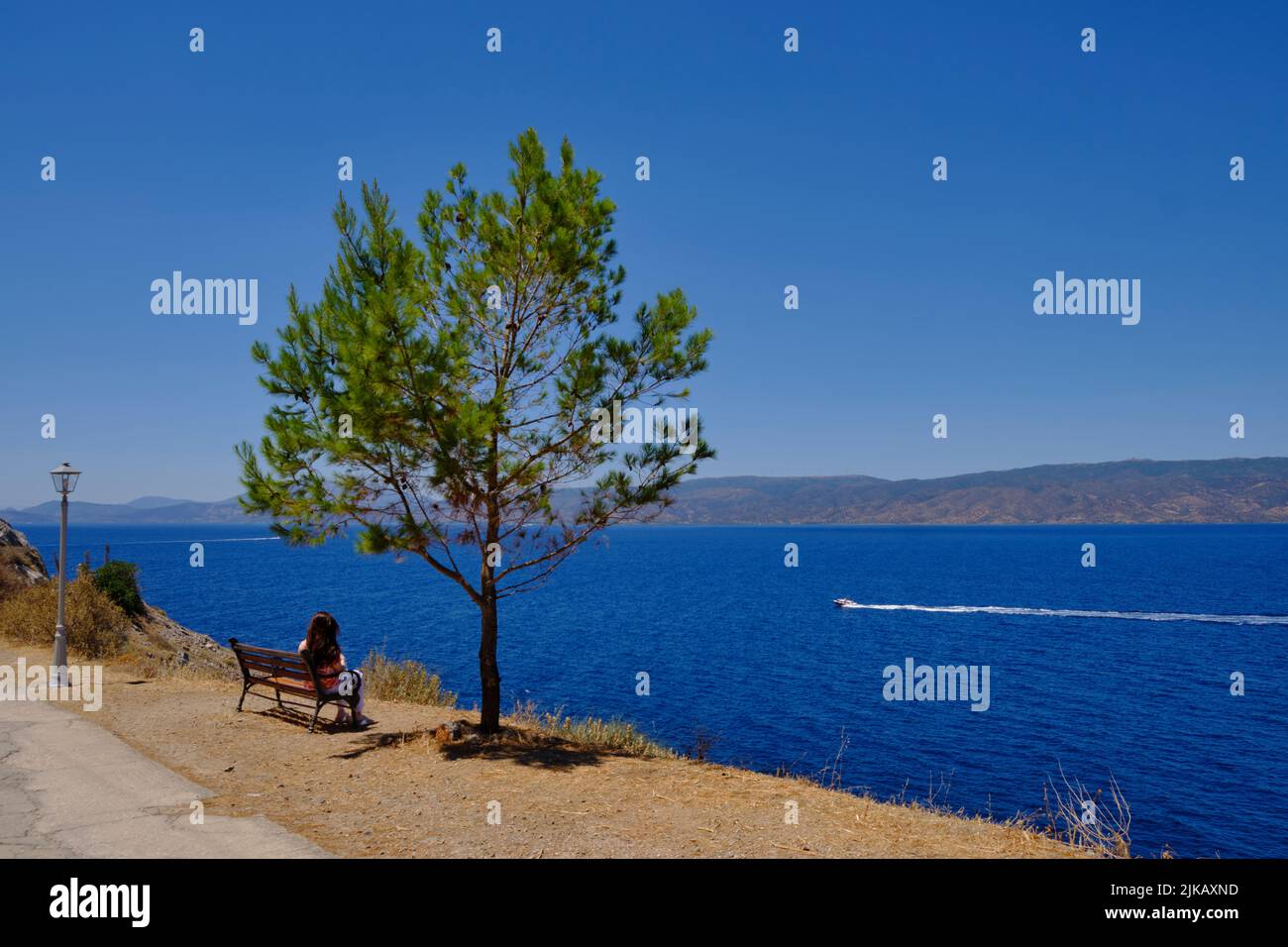 Tourist taking in the views on the island of Hydra in Greece in Summer Stock Photo