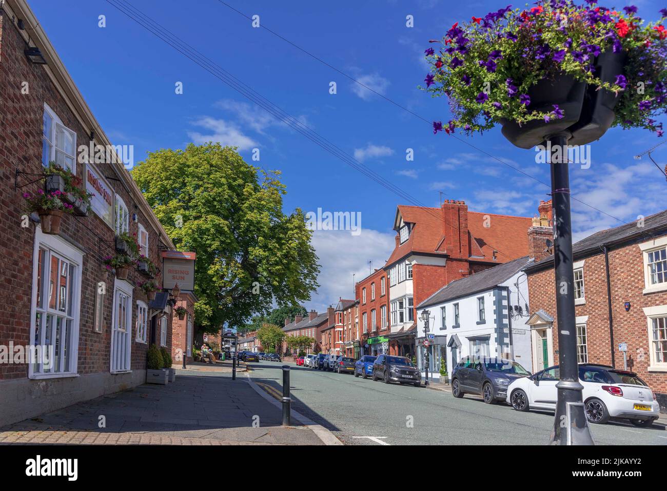 The High stret in Tarporle, Cheshire with the Rising Sun pub on the left. Stock Photo