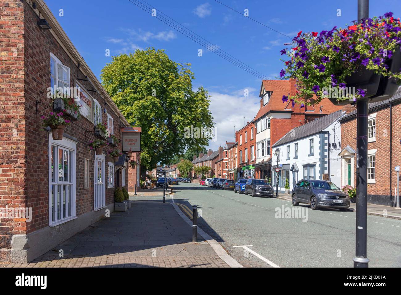 The High stret in Tarporle, Cheshire with the Rising Sun pub on the left. Stock Photo