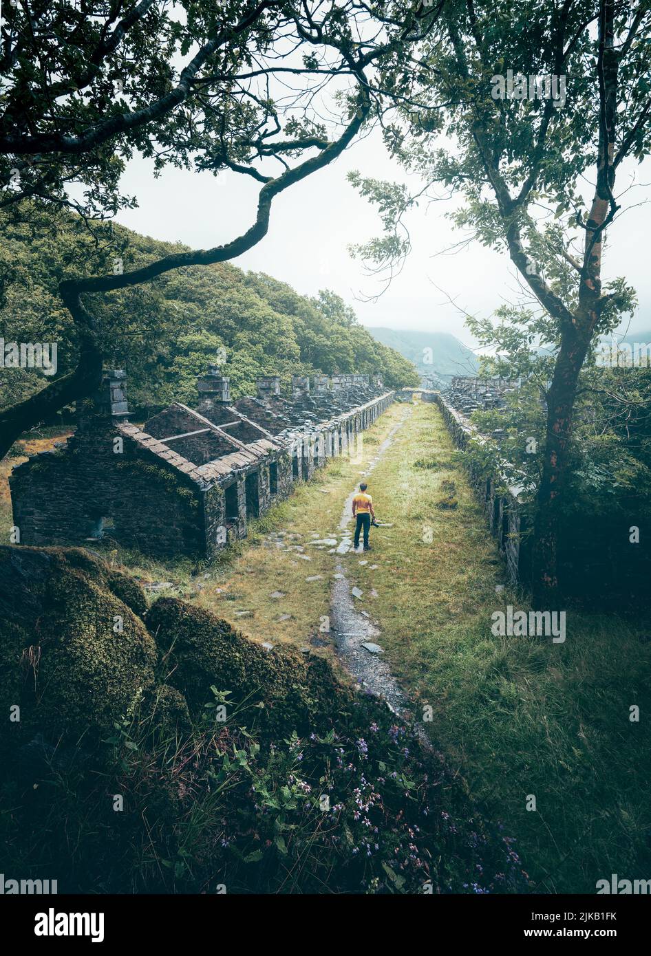 Slate Quarry Barracks, an abandoned area set in the mountains. UK: THESE STUNNING images of a lone traveller crossing incredible landscapes prove how Stock Photo